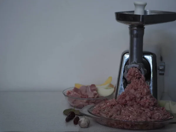 Raw rabbit meat. Minced meat twisted through a meat grinder on a wooden ancient table. Sliced meat prepared for torsion.