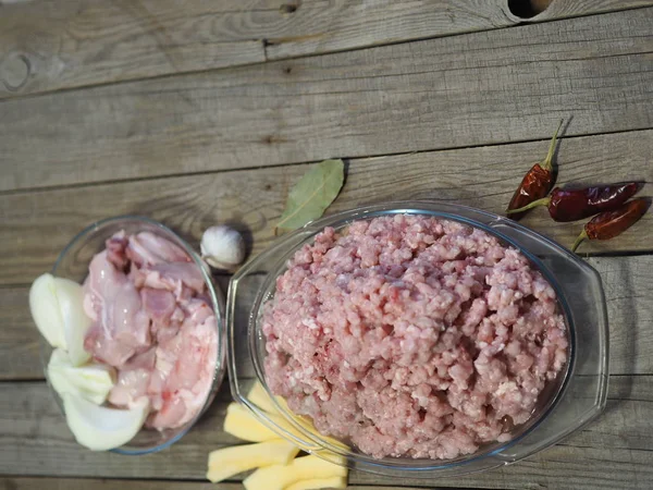 Raw rabbit meat. Minced meat twisted through a meat grinder on a wooden ancient table. Sliced meat prepared for torsion.