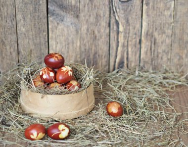 İsa dirildi. Yuvadaki kurumuş çimlerin üzerinde soğan boyalı yumurtalar. Geleneksel bahar bayramı ortodoks yemekleri. Paskalya Pazarı.