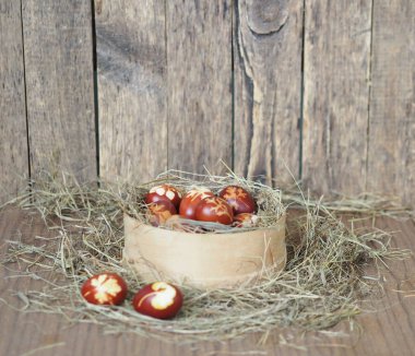 İsa dirildi. Yuvadaki kurumuş çimlerin üzerinde soğan boyalı yumurtalar. Geleneksel bahar bayramı ortodoks yemekleri. Paskalya Pazarı.