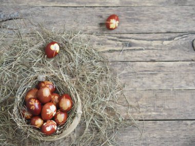 İsa dirildi. Yuvadaki kurumuş çimlerin üzerinde soğan boyalı yumurtalar. Geleneksel bahar bayramı ortodoks yemekleri. Paskalya Pazarı.