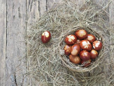 İsa dirildi. Yuvadaki kurumuş çimlerin üzerinde soğan boyalı yumurtalar. Geleneksel bahar bayramı ortodoks yemekleri. Paskalya Pazarı.