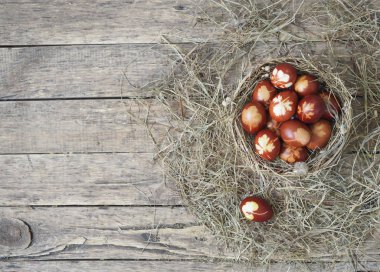 İsa dirildi. Yuvadaki kurumuş çimlerin üzerinde soğan boyalı yumurtalar. Geleneksel bahar bayramı ortodoks yemekleri. Paskalya Pazarı.