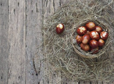 İsa dirildi. Yuvadaki kurumuş çimlerin üzerinde soğan boyalı yumurtalar. Geleneksel bahar bayramı ortodoks yemekleri. Paskalya Pazarı.