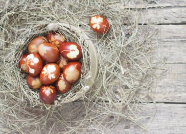 İsa dirildi. Yuvadaki kurumuş çimlerin üzerinde soğan boyalı yumurtalar. Geleneksel bahar bayramı ortodoks yemekleri. Paskalya Pazarı.