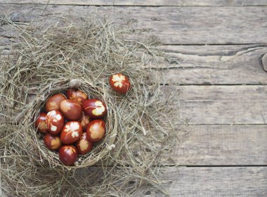 İsa dirildi. Yuvadaki kurumuş çimlerin üzerinde soğan boyalı yumurtalar. Geleneksel bahar bayramı ortodoks yemekleri. Paskalya Pazarı.