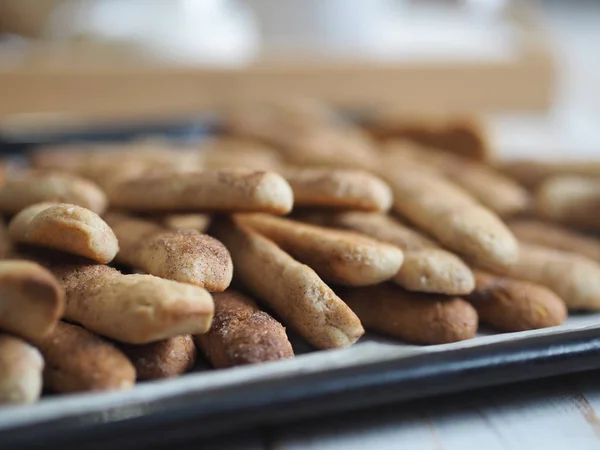 Hausgemachte Shortbread-Kekse mit Zimt und Nüssen auf einem schwarzen Backblech für den Ofen. Wir backen Plätzchen. — Stockfoto