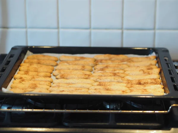 Homemade shortbread biscuits with cinnamon and nuts on a black baking sheet for the oven. We bake cookies. — Stock Photo, Image