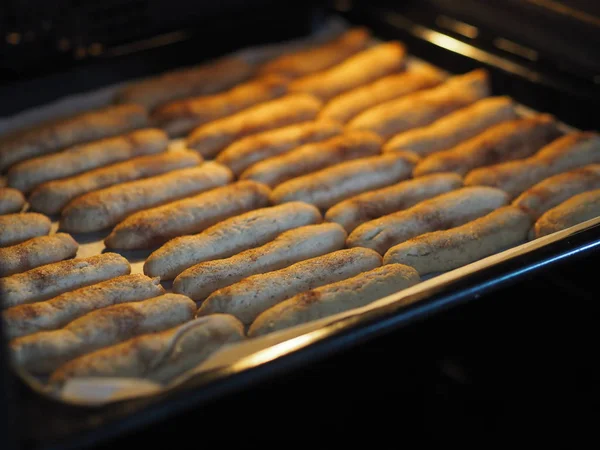 Hausgemachte Shortbread-Kekse mit Zimt und Nüssen auf einem schwarzen Backblech für den Ofen. Wir backen Plätzchen. — Stockfoto