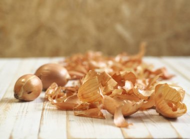 İlaçta soğan kabuğu kullanımı ve Paskalya yumurtalarını boyamak için. Ahşap zemin üzerinde soğan ve soğan..