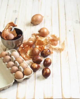 Paskalya yumurtaları eski ahşap bir arka planda taze otlarla birlikte soğan kabuğu boyadı. Yumurtaları eski çevre dostu yöntemle soyulmuş soğanla boyuyoruz. Paskalya için hazırlanıyorum..