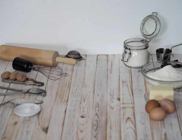 Utensilios de cocina con ingredientes para productos culinarios. fondo blanco de madera . — Foto de Stock