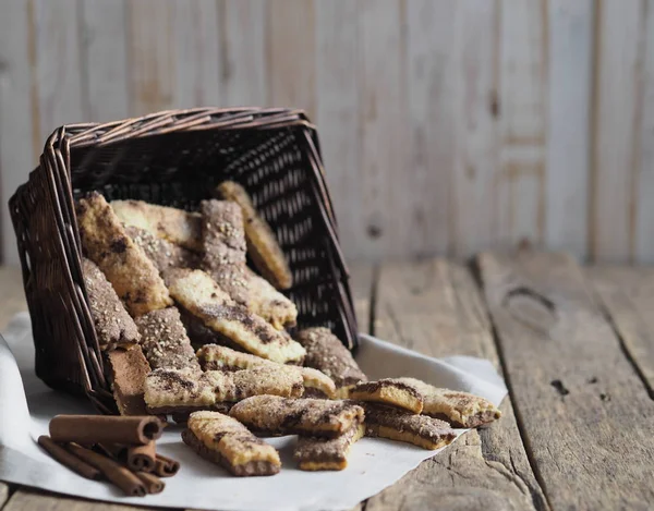 Homemade sandwich puff pastry chocolate cookies in a wicker natural basket of vines. Wooden ancient table.