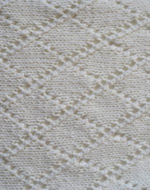 Beyaz iplikten örülmüş, el yapımı bir kumaş parçası. Yukarıdan bak. Dikey.