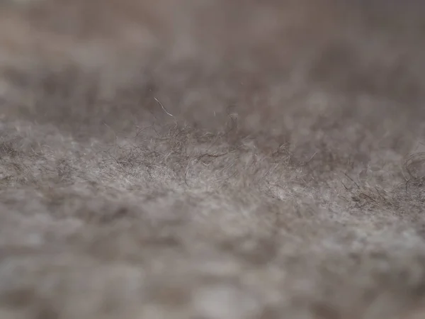 Fragment of a knitted fabric of a fluffy shawl handmade from natural goat hair of brown color. View from above. Horizontal. — Stock Photo, Image