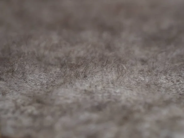 Fragment d'un tissu tricoté d'un châle moelleux fait à la main à partir de poils de chèvre naturels de couleur brune. Vue d'en haut. Horizontal . — Photo