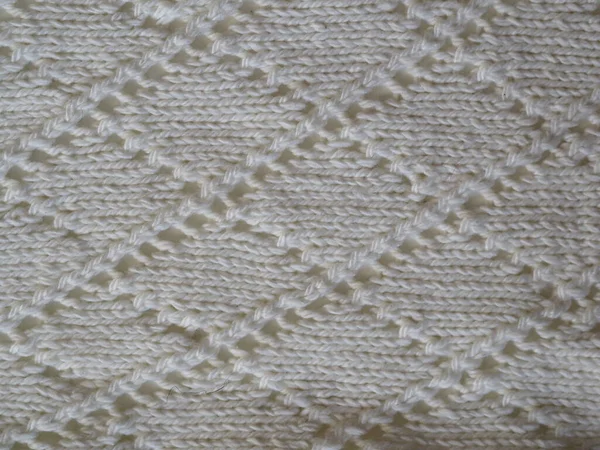 Fragment of a knitted fabric of openwork manual knitting from white yarn. View from above. Horizontal. — Stock Photo, Image