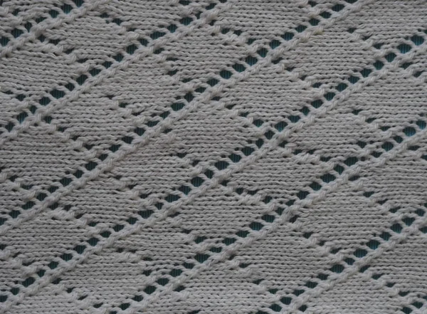 白い糸から透かし彫り手編みのニット生地のフラグメント。上からの眺め。水平. — ストック写真