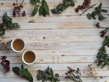 Kurutulmuş şifalı bitkiler kullanma kavramı. Farklı şifalı bitkilerle ahşap beyaz arka plan. Bitkiler ve çiçeklerle beden eğitimi..