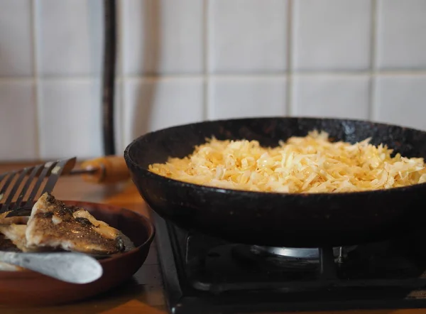 Домашняя кухня. Жареная капуста в черной кастрюле на костре. Подготовка начинки для пирога с капустой . — стоковое фото