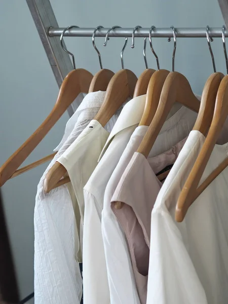 Hangers hangers with light male and female clothes. Gray background. — Stock Photo, Image