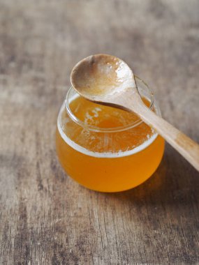 Kahverengi ahşap bir masada ballı krep. Krepleri kaşıktan bal ile doldur. Shrovetide için arkaplan.