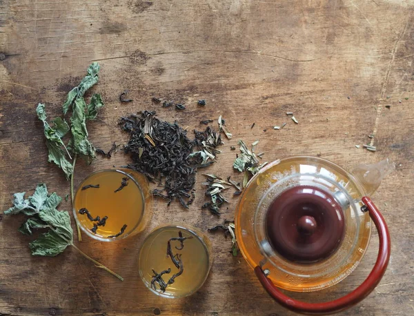 Трав'яні ліки. Концепція користі для здоров'я зеленого трав'яного чаю. Чайник і чашки на дерев'яному коричневому столі з мартинами і лікувальними — стокове фото