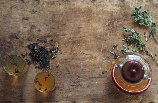 Medicina herbácea. O conceito dos benefícios para a saúde do chá de ervas verdes. Bule e xícaras em uma mesa marrom de madeira com gaivotas e medicinais — Fotografia de Stock