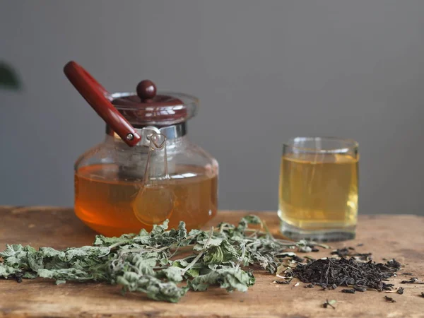 Medicina herbácea. O conceito dos benefícios para a saúde do chá de ervas verdes. Bule e xícaras em uma mesa marrom de madeira com gaivotas e medicinais — Fotografia de Stock