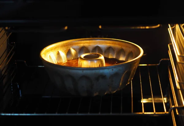 Feestelijk thuisbakken in de oven in de vorm van een ovenschaal. Ronde chocolade muffin, grote muffin of cake met chocolade glazuur op een donkere houten achtergrond. Plaats voor tekst. — Stockfoto