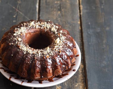 Ev yapımı şenlikli pastalar. Yuvarlak çikolatalı kek, büyük sünger kek ya da koyu ahşap arka planda çikolatalı kremalı pasta. Mesaj için yer. Yan görünüm.