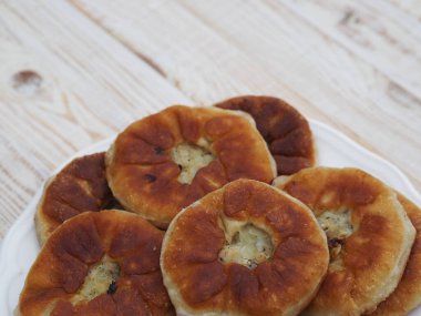 Beyaz ahşap bir masada et ile ev yapımı pişirme. Yan görünüm.