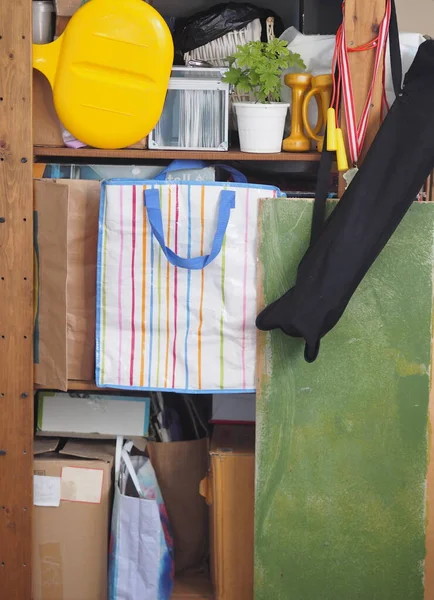 Boxes with old things, with parts for filming, accessories on shelves for storage. Household unnecessary things. Wooden shelves.