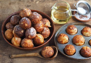 Ev yapımı fırında çörek. Kızarmış, sebze yağında kızartma tavasında. Tatil ve günlük yemek. Kızartma tavalı olan kahverengi ahşap arka plan.