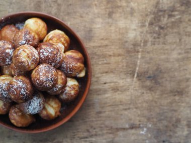 Ev yapımı fırında çörek. Kızarmış, sebze yağında kızartma tavasında. Tatil ve günlük yemek. Mesaj için yer. Kahverengi ahşap arka plan. Yakın plan..