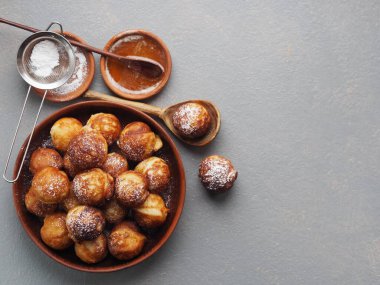 Ev yapımı fırında çörek. Kızarmış, sebze yağında, gri bir kırsal masada kızartma tavasında. Tatil ve günlük yemek. Metin için yer.