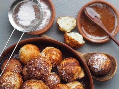 Ev yapımı fırında çörek. Kızarmış, sebze yağında, gri bir kırsal masada kızartma tavasında. Tatil ve günlük yemek. Metin için yer.