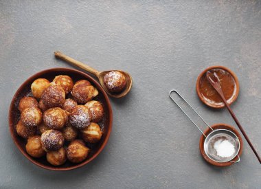 Ev yapımı fırında çörek. Kızarmış, sebze yağında, gri bir kırsal masada kızartma tavasında. Tatil ve günlük yemek. Metin için yer.