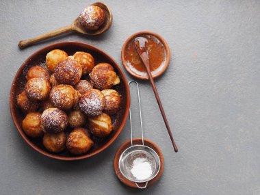 Ev yapımı fırında çörek. Kızarmış, sebze yağında, gri bir kırsal masada kızartma tavasında. Tatil ve günlük yemek. Metin için yer.