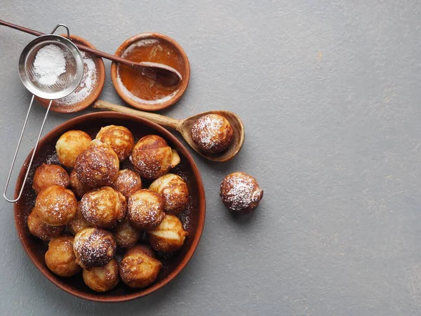 Ev yapımı fırında çörek. Kızarmış, sebze yağında, gri bir kırsal masada kızartma tavasında. Tatil ve günlük yemek. Metin için yer.