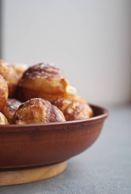 Ev yapımı fırında çörek. Kızarmış, sebze yağında, gri bir kırsal masada kızartma tavasında. Tatil ve günlük yemek. Metin için yer.