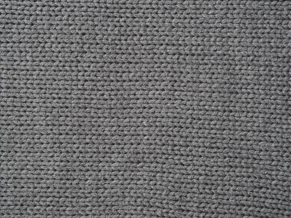 Gray knitted textured background, knit with facial loops. Hand knitting.