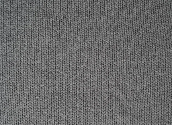 Gray knitted textured background, knit with facial loops. Hand knitting.