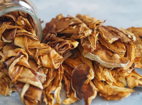 Dried melon chips in a glass jar on a wooden background. Home cooking. Natural healthy product. Place for text.