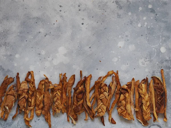 Dried melon chips on a wooden background are laid out in a row. Home cooking. Natural healthy product. Place for text. Top view.