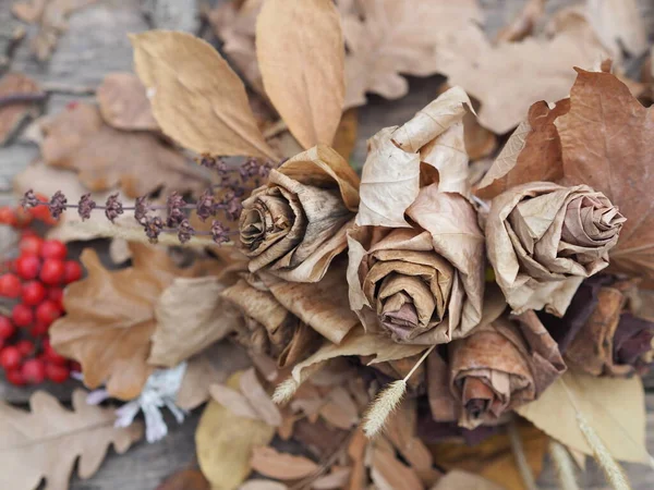 Wallpaper, texture. Autumn background of roses made from dry leaves.Autumn crafts with your own hands.Photo for the manual.