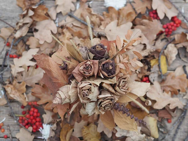 Wallpaper, texture. Autumn background of roses made from dry leaves. Autumn crafts with your own hands.Photo for the manual.