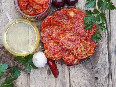 Sağlıklı beslenme kavramı. Kurutulmuş meyve ve sebzelerin faydaları. Ahşap bir masada pişirmek için malzemeli kurutulmuş domates cipsi. Yukarıdan görüntü, mesaj için yer. Kırsal kesimde kış için sonbahar hazırlıkları