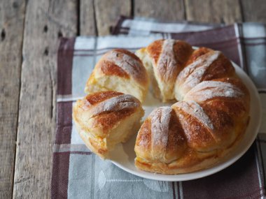 Kırsal ahşap masada susam tohumlu ev yapımı mayalı pogaça. Noel ya da Paskalya bayramları için şenlikli ekmek.