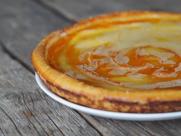 Balkabağından yapılmış nefis ev yapımı peynirli kek, çırpılmış yumurtaların üzerine şeker dökülmüş, ahşap arka planda, yan manzaralı. Yazı için yer var..